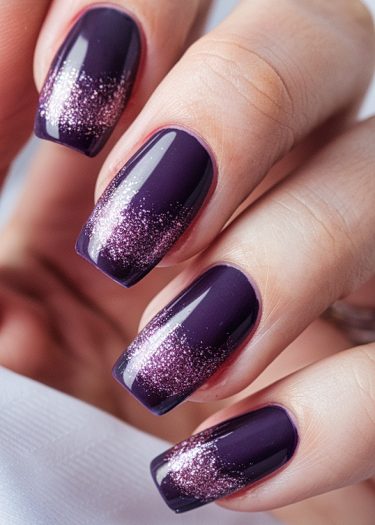 Elegant deep purple nails with rose-gold glitter tips for a chic manicure look.