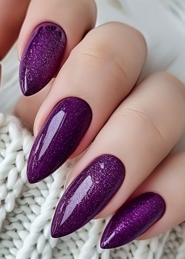 Elegant long purple glitter nails with a glossy finish, perfect for a sophisticated look.