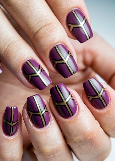 Elegant deep plum and gold geometric nail art with precise designs on manicured nails.