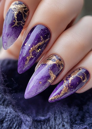 Stunning purple and gold stiletto nail art with luxurious ombre and marbling design.