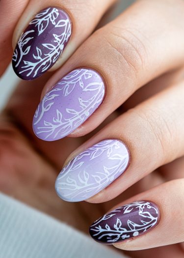 Elegant deep purple and lavender nail art with botanical designs for a chic manicure.