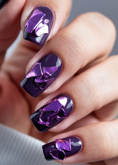 Elegant deep purple metallic nail art with intricate designs and high-shine finish.