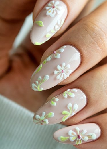 Elegant almond-shaped nails with delicate pink floral art featuring daisies and green foliage.