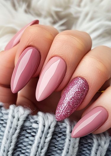 Elegant dusty pink manicure with almond-shaped nails and a glittery accent on the ring finger.