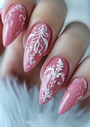 Elegant dusty pink stiletto nails with intricate white lace patterns for a chic manicure.