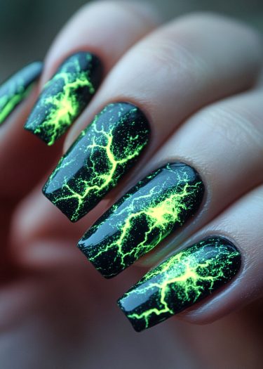 Striking black nails with electrifying neon green lightning bolt nail art design.