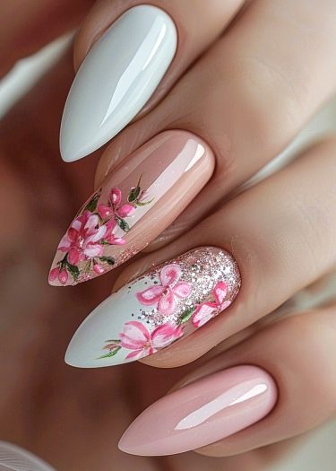 Elegant almond nail art featuring floral designs, glitter accents, and a polished finish.