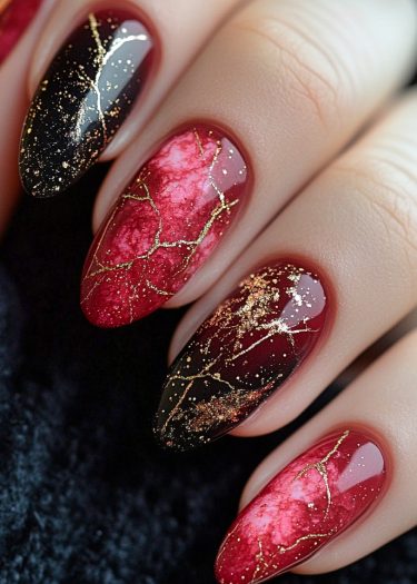 Elegant almond nail art in red and black with gold marbling and glossy finish.