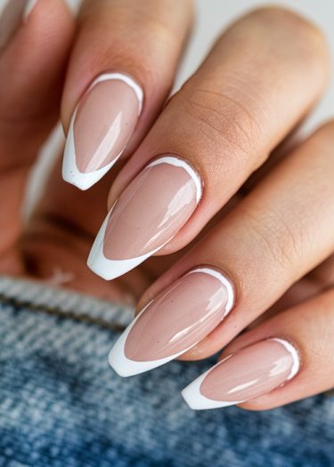 Elegant French manicure on almond-shaped nails, showcasing a glossy finish and precise white tips.