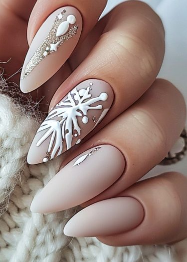 Elegant almond-shaped nails featuring winter-themed designs, including snowflakes and silver accents.