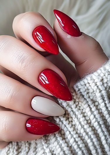 Elegant almond-shaped nails in glossy red with glitter, against a cozy beige background.