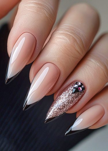 Stunning stiletto nail design with gradient nude to black and rose gold glitter accents.