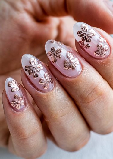 Elegant almond nails featuring rose gold floral accents on a glossy pink base.