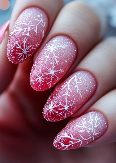 Elegant almond nails with snowflake designs and glitter in a festive winter gradient.