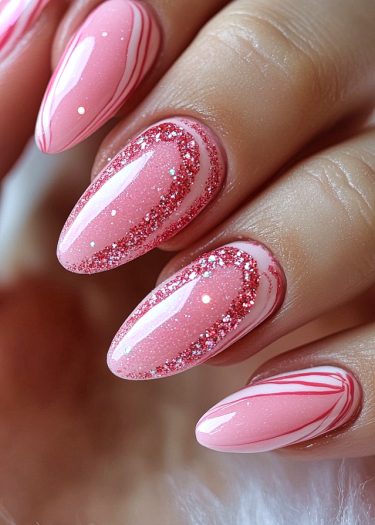 Elegant almond-shaped pink nails with marble design and glitter accents for a stunning manicure.