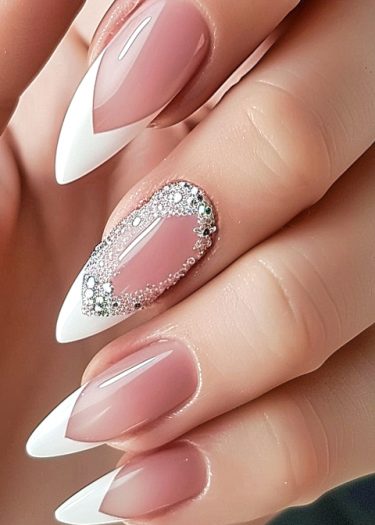 Elegant almond-shaped nails with blush pink base and intricate crystal embellishments.