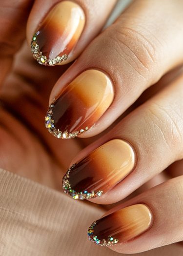 Elegant autumn nails with a gradient design and glittery tips for a chic look.