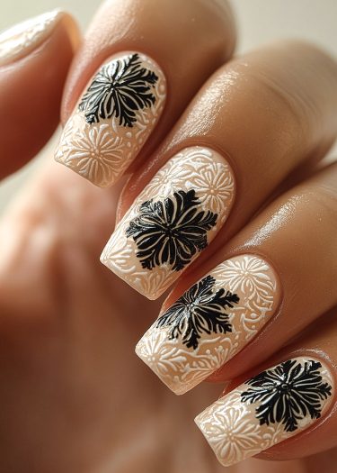 Elegant black floral nail art with embossed white details for a luxurious manicure.