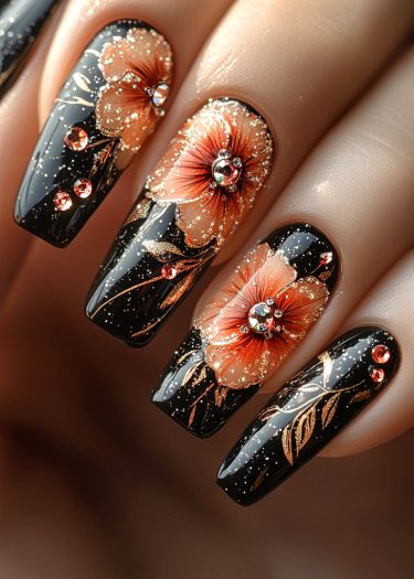 Elegant black floral nail art with shimmering peach flowers and dazzling rhinestones.