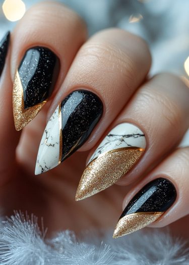 Elegant stiletto nails featuring black, gold, and marble designs for a luxurious manicure.