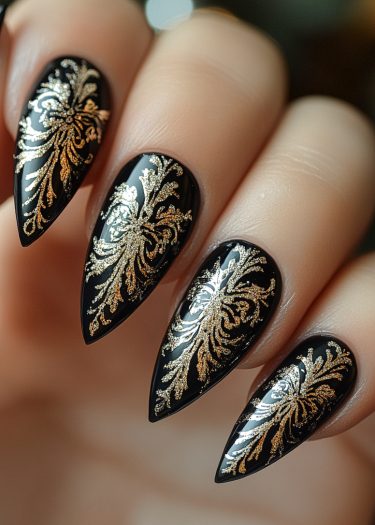 Elegant black and gold stiletto nail art with intricate floral designs.