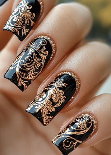 Elegant black and gold nail art featuring intricate designs on glossy, manicured nails.