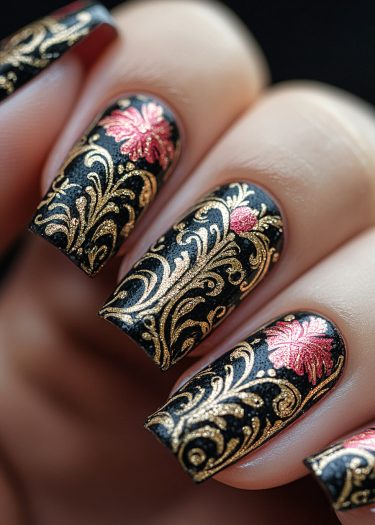 Elegant black and gold nail art with intricate floral designs and a glossy finish.