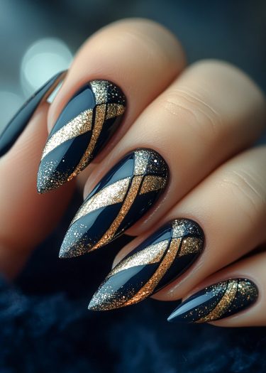 Stunning black and gold stiletto nail art featuring intricate glitter designs for a glamorous look.