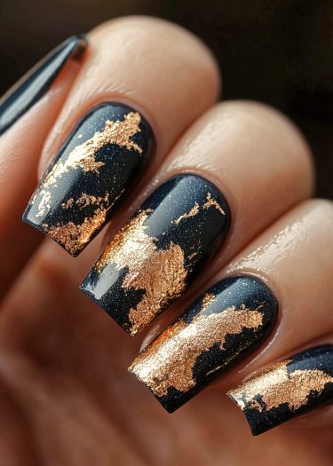 Elegant navy blue nails with gold foil design showcasing sophisticated nail art.