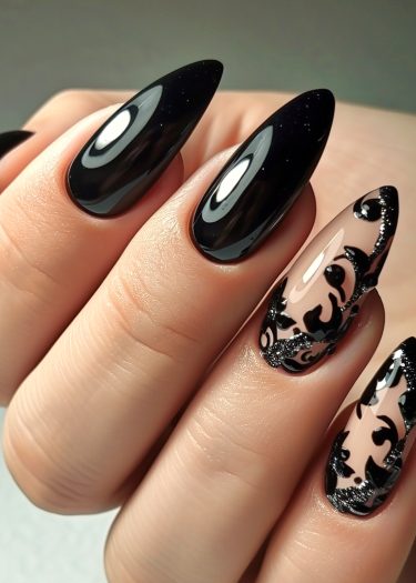 Stunning stiletto nails with glossy black polish and intricate floral designs create elegant nail art.