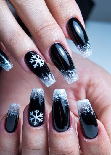 Elegant black nail art with frosty gradient and intricate snowflake designs for a stunning look.