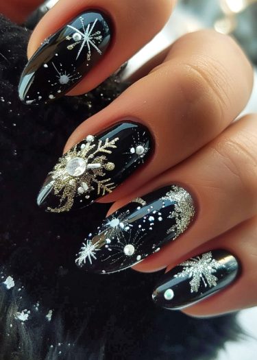 Elegant black nail art featuring silver snowflakes, pearls, and crystals for a festive look.