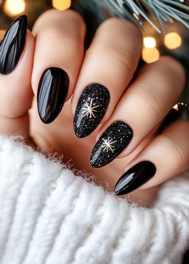 Elegant black nail art with starry design and gold accents on cozy sweater backdrop.