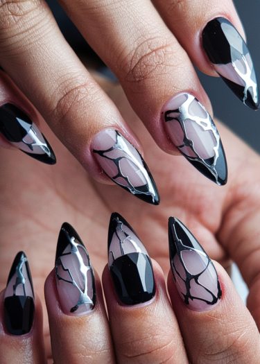 Elegant black nail art with translucent details and silver accents for a chic, modern look.