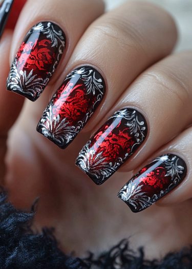 Elegant black and red nail art featuring intricate floral designs and metallic accents.