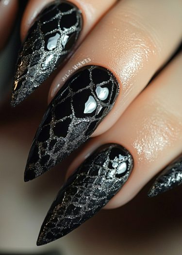 Elegant black and silver stiletto nails with a stunning crackle design showcase sophisticated nail art.