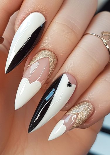 Elegant black and white stiletto nails with gold accents showcasing intricate nail art designs.