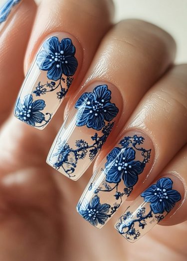 Elegant blue floral nail art with intricate designs on a glossy base.