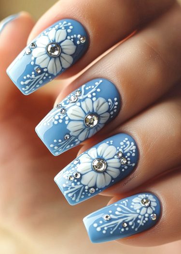 Elegant blue floral nails with rhinestones, showcasing intricate designs and sophisticated style.