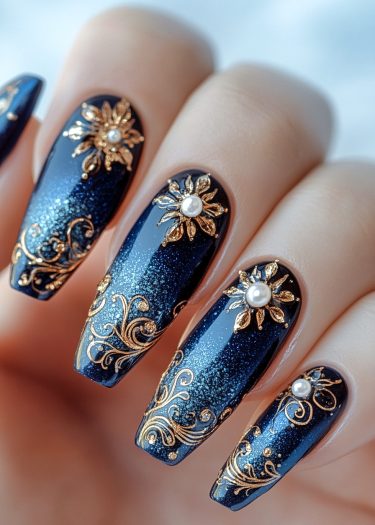 Elegant blue and gold nail art featuring shimmering gradient, floral designs, and pearl accents.