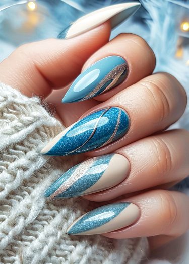 Elegant blue nail art features intricate designs and a stylish almond shape manicure.