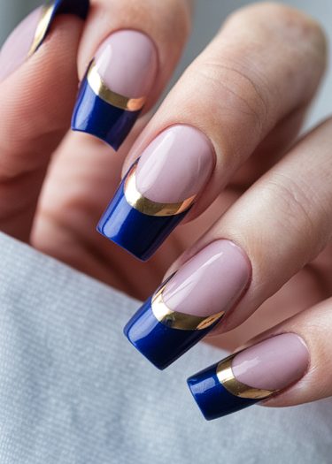 Elegant blue nail art with pink base and gold accents for a chic manicure look.