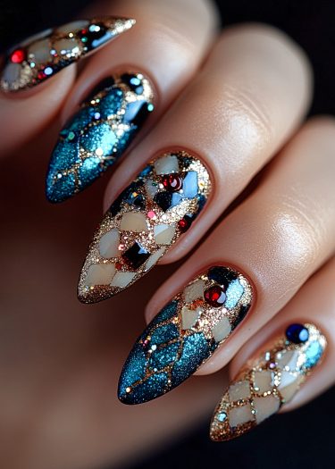 Elegant blue almond nails with shimmering gold, intricate patterns, and sparkling rhinestones for a luxurious look.