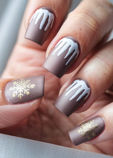 Elegant brown matte nail art featuring snow drips and gold snowflakes for winter style.