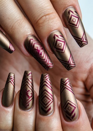 Elegant coffin-shaped bronze nails with intricate burgundy geometric patterns for stylish nail art.