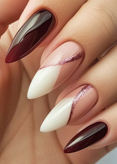 Elegant burgundy and nude nails with glitter, showcasing a sophisticated almond shape manicure.