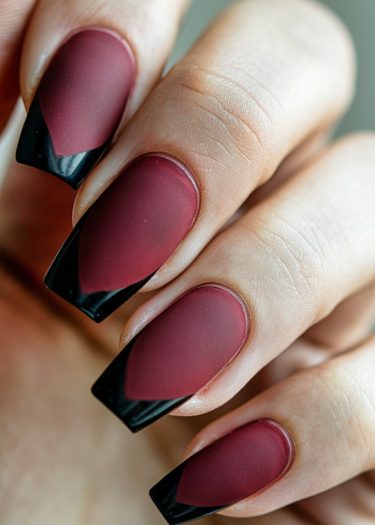 Elegant burgundy nails with glossy black tips showcase sophisticated, modern nail design artistry.