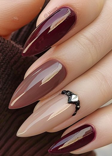 Elegant burgundy and mauve pink stiletto nails with decorative accents for sophisticated nail art.