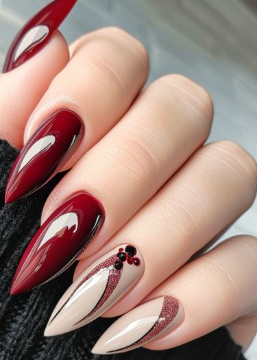 Elegant burgundy nail art featuring intricate designs and glossy finishes on almond-shaped nails.