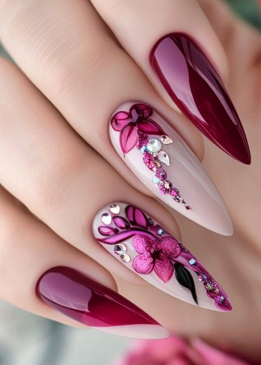 Elegant burgundy nail art featuring intricate designs, glitter, and rhinestones for a luxurious look.